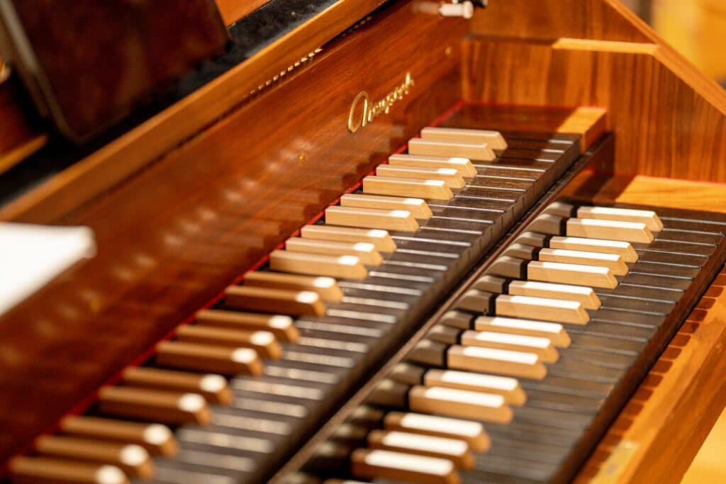 Nahaufnahme von zwei übereinanderliegenden Manualen einer hölzernen Orgel mit hellen und dunklen Tasten.