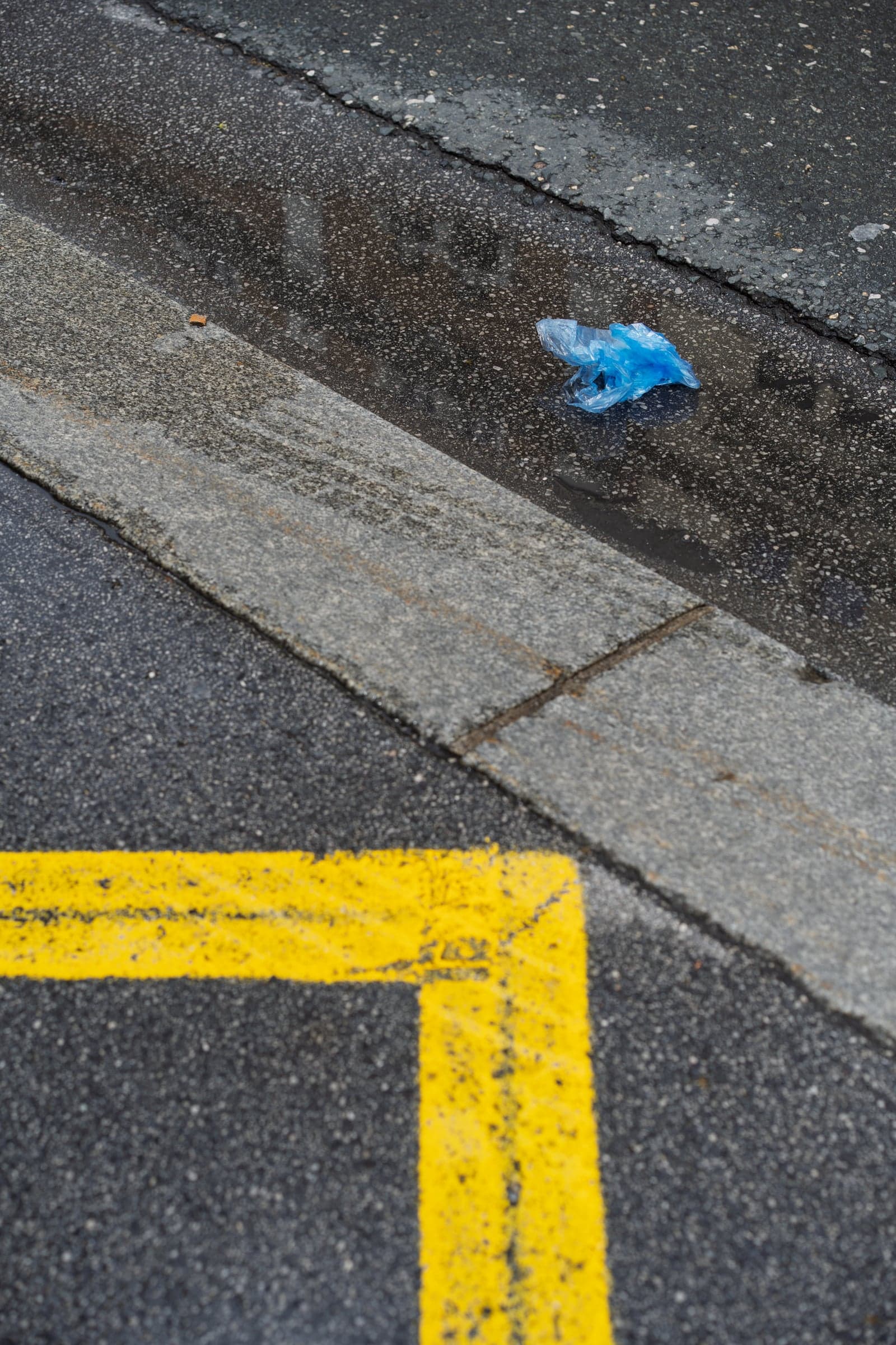 Eine blaue Plastiktüte am Straßenrand, ein beiläufiger Moment aufmerksam gesehen
